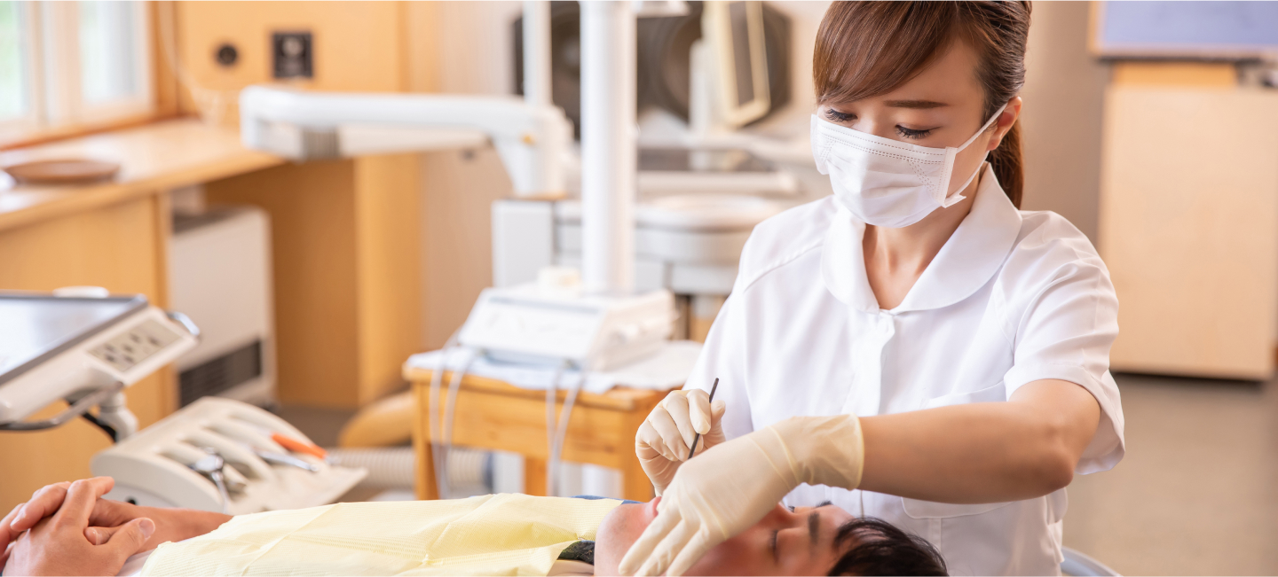 歯科医師が患者の口内を治療しているシーン